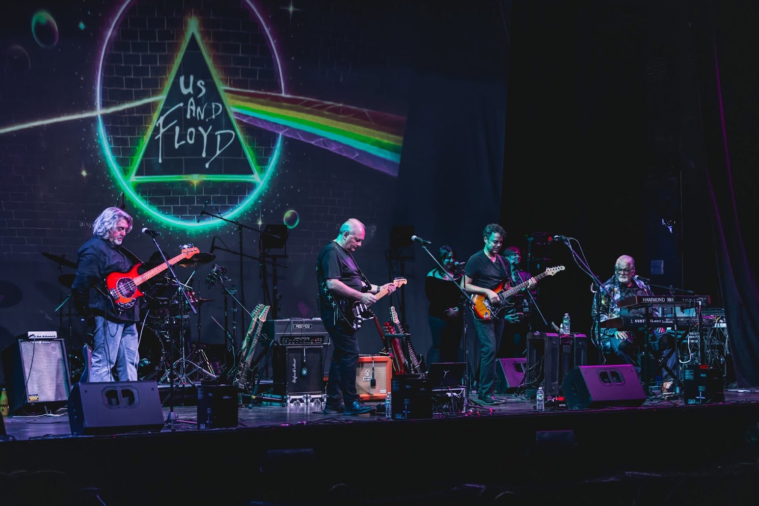 Us And Floyd on stage with a prism backdrop