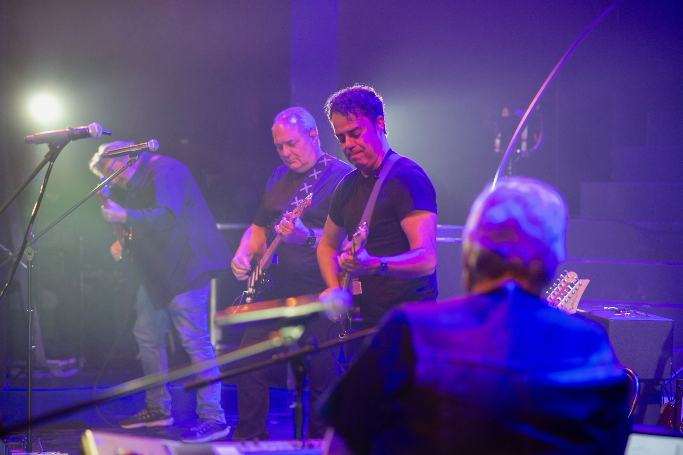 Paul O'Dell playing bass on a stage under purple and blue light