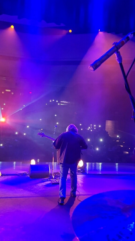 Paul O'Dell on stage, from behind, looking out at the house