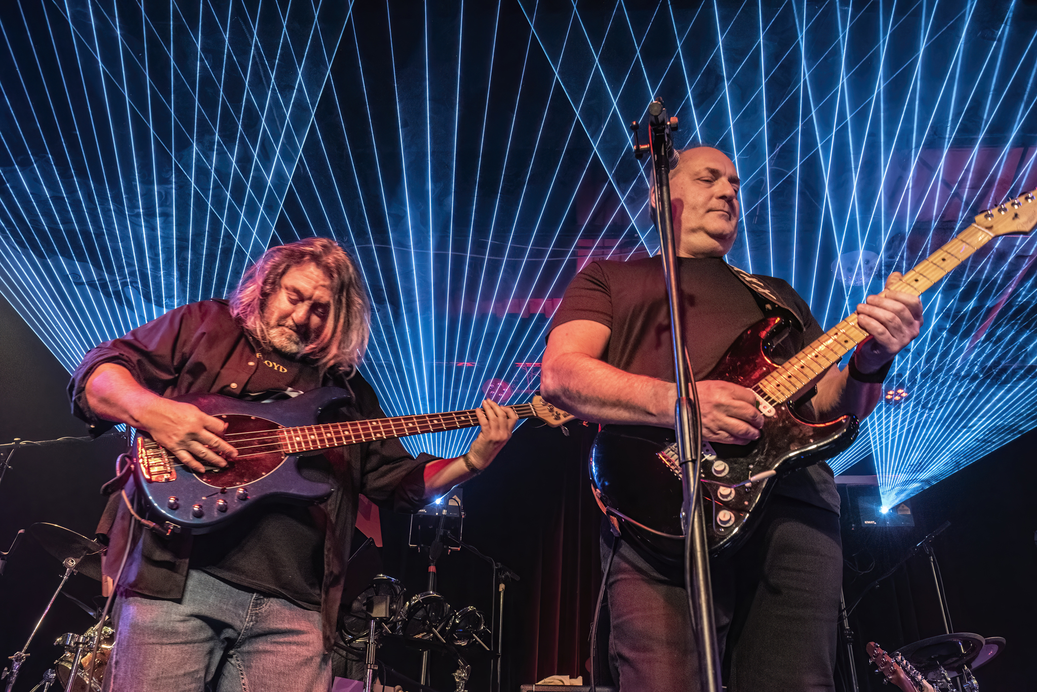 Us And Floyd performing live under blue lasers